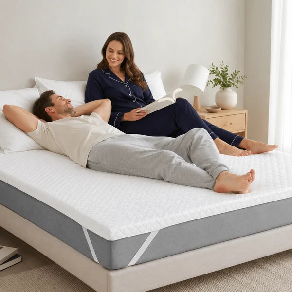 Couple détendu sur le surmatelas en gel, chambre chaleureuse