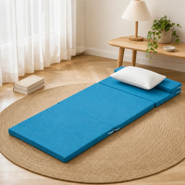 Matelas de sol coin lecture bleu, deplie sur un tapis en jute avec oreiller blanc et livres