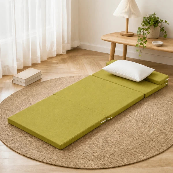 Matelas de sol coin lecture vert olive, deplie sur un tapis en jute avec oreiller blanc et livres