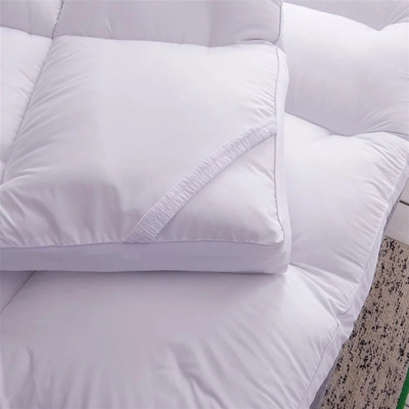 Détail du coin du surmatelas épais replié avec un oreiller assorti
