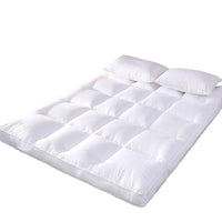 Surmatelas épais matelassé avec deux oreillers, vue de face sur fond blanc